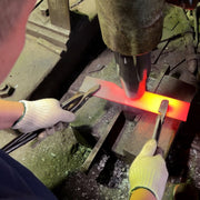 Takeshi Saji Knives bladesmith hammering a heated metal to form a blade