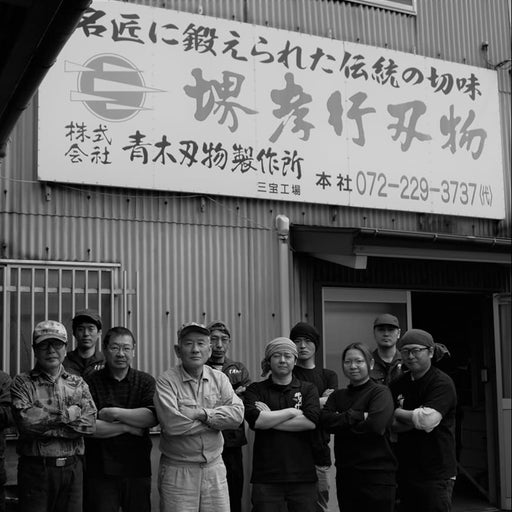 The whole team of craftsmen that make Sakai TAKAYUKI for Aoki Hamono in front of the entrance of the workshop