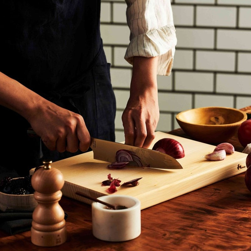Chef chopping onions with NAGOMI Santoku Knife 180mm crafted by Mitsuboshi Cutlery