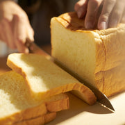 Closeup on hands slicing bread with NAGOMI Bread Knife 205mm by Mitsuboshi Cutlery