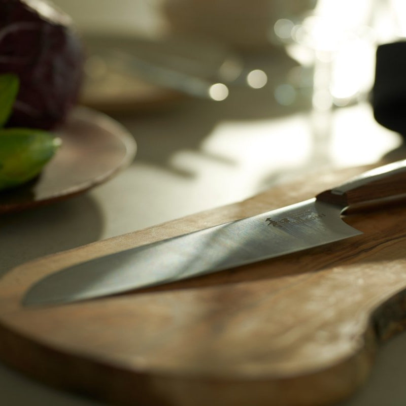 NAGOMI Santoku Knife 180mm crafted by Mitsuboshi Cutlery on a wooden cutting board