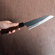 Hand holding a Nishida Hamono Kurouchi Gyuto Knife 165mm