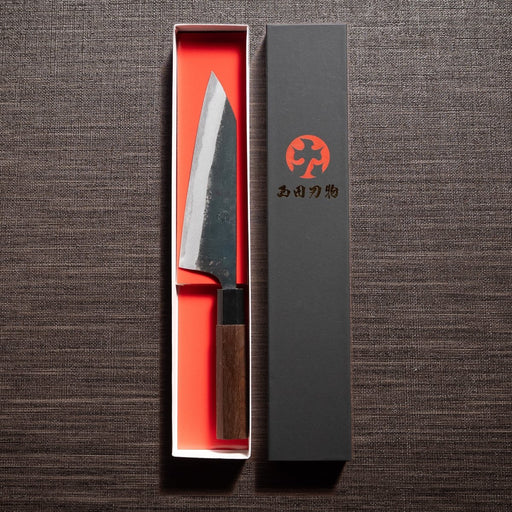 Nishida Hamono Kurouchi Gyuto Knife 165mm in an open box next to the cover with the Japanese character Nishida Hamono logo