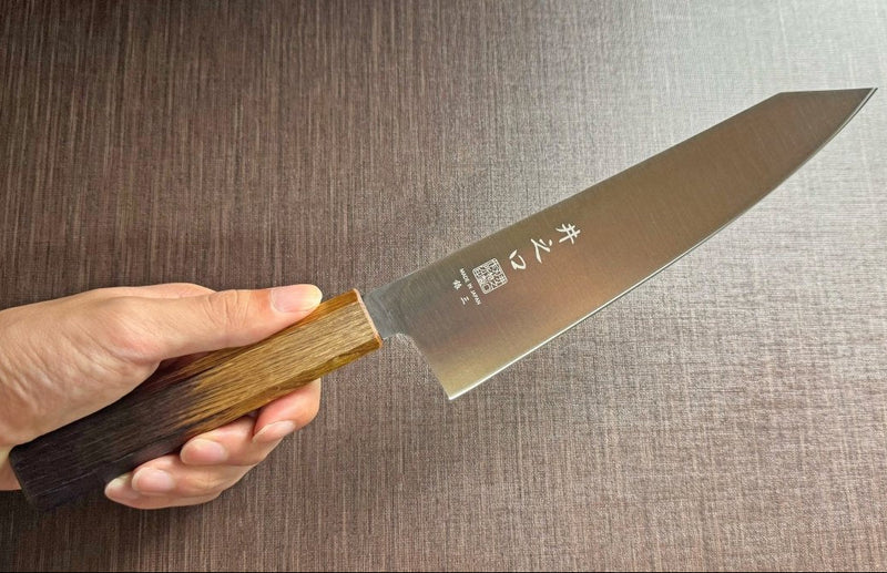 Japanese-style Kiritsuke Santoku Kitchen Knife 21cm crafted by Inoguchi Hamono in Seki, Japan with light brown Japanese Oak handle held in hand