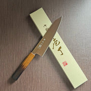 Japanese-style Kiritsuke Santoku Kitchen Knife 21cm crafted by Inoguchi Hamono in Seki, Japan with light brown Japanese Oak handle with box on brown background