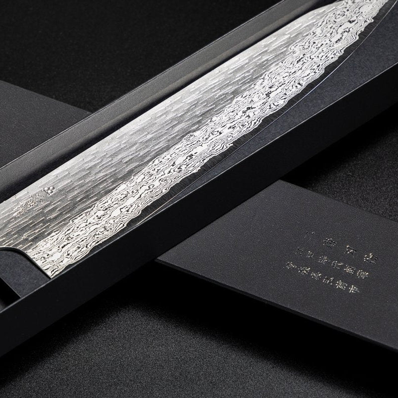 Closeup on blade of VG XEOS Gyuto Knife 25.5cm crafted by Nigara Hamono in elegant box