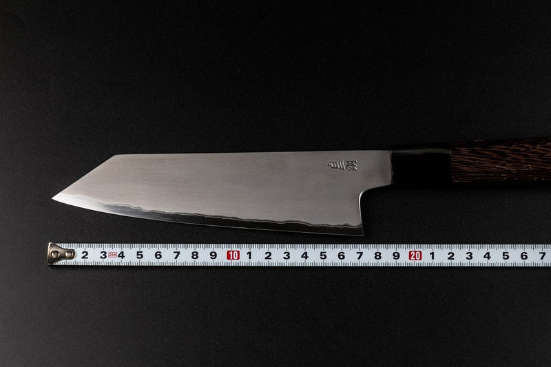 Blade of Sakai TAKAYUKI Kiritsuke 180mm by Aoki Hamono over a measure tape that shows the length of the blade