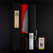 Sakai TAKAYUKI Gyuto 210mm by Aoki Hamono inside its red inner box next to its Japanese characters label cover, product instructions card and guaranteee card, all vertically aligned