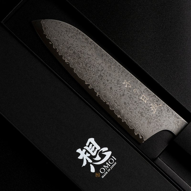 Omoi Santoku stainless steel Kitchen Knife 180mm crafted by Nenohi Cutlery in box next to box cover zoomed in 