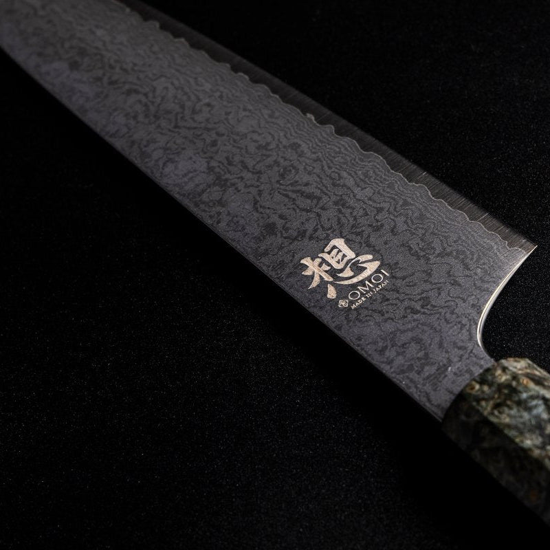 Closeup of back engraving on the blade of Omoi Gyuto stainless steel Kitchen Knife 180mm crafted by Nenohi Cutlery on black background 