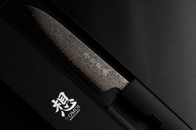 Omoi Gyuto Kitchen Knife 180mm crafted by Nenohi Cutlery in black box next to box cover with Omoi Made in Japan zoomed in