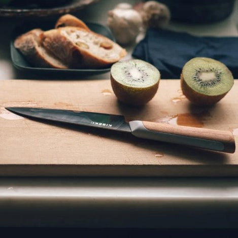 Closeup of a cutting board with fruit and a KISEKI Petty Knife 