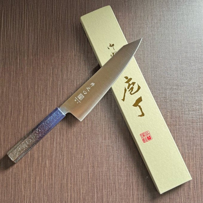 Japanese-style Kiritsuke Santoku Kitchen Knife 21cm crafted by Inoguchi Hamono in Seki, Japan with Japanese Oak handle with gradient blue urushi lacquer with box on brown background