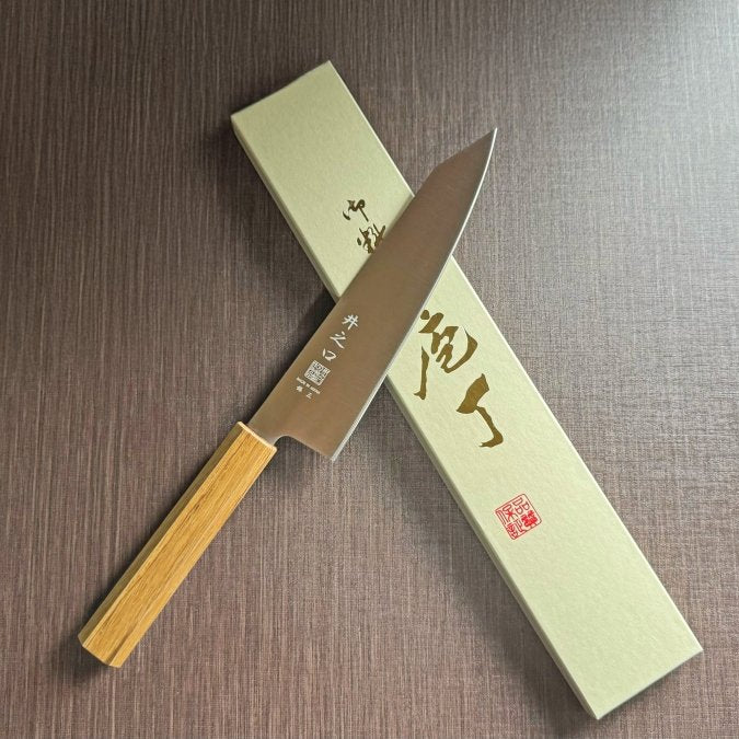 Japanese-style Kiritsuke Santoku Kitchen Knife 21cm crafted by Inoguchi Hamono in Seki, Japan with light brown Japanese Oak handle with box on brown background