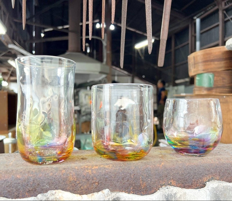 工房の茶色い大理石の表面に副島硝子の手作りレインボーグラスが3つ展示されている