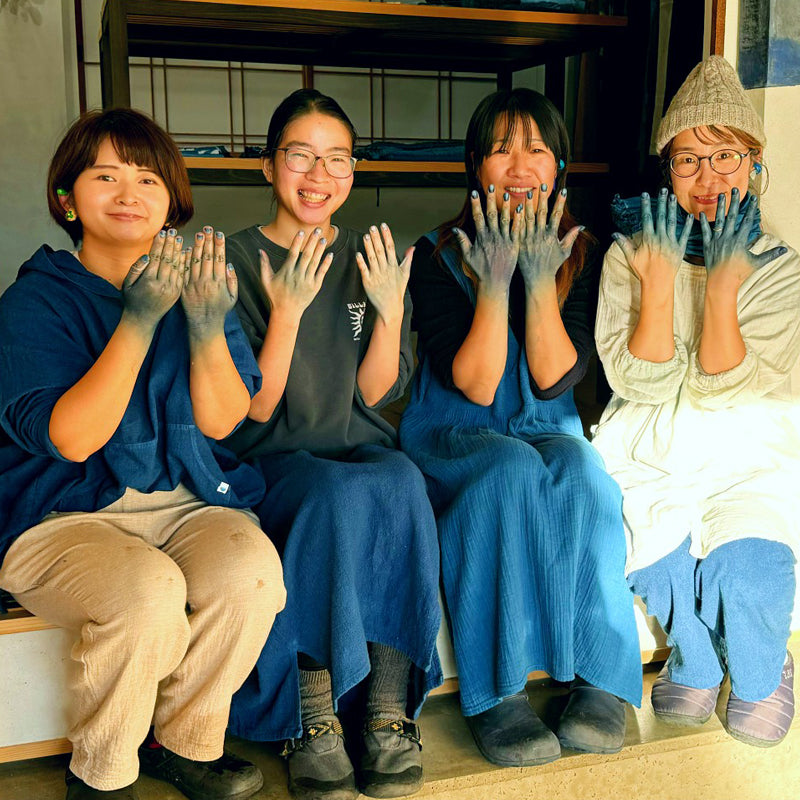 Portrait of Chizu Blue artisans smiling and showing their blue dyed hands