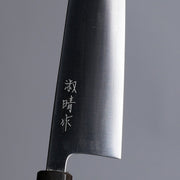Closeup on engraving on Sakoda Hamono Polished Aogami Super Gyuto 180mm on grey background