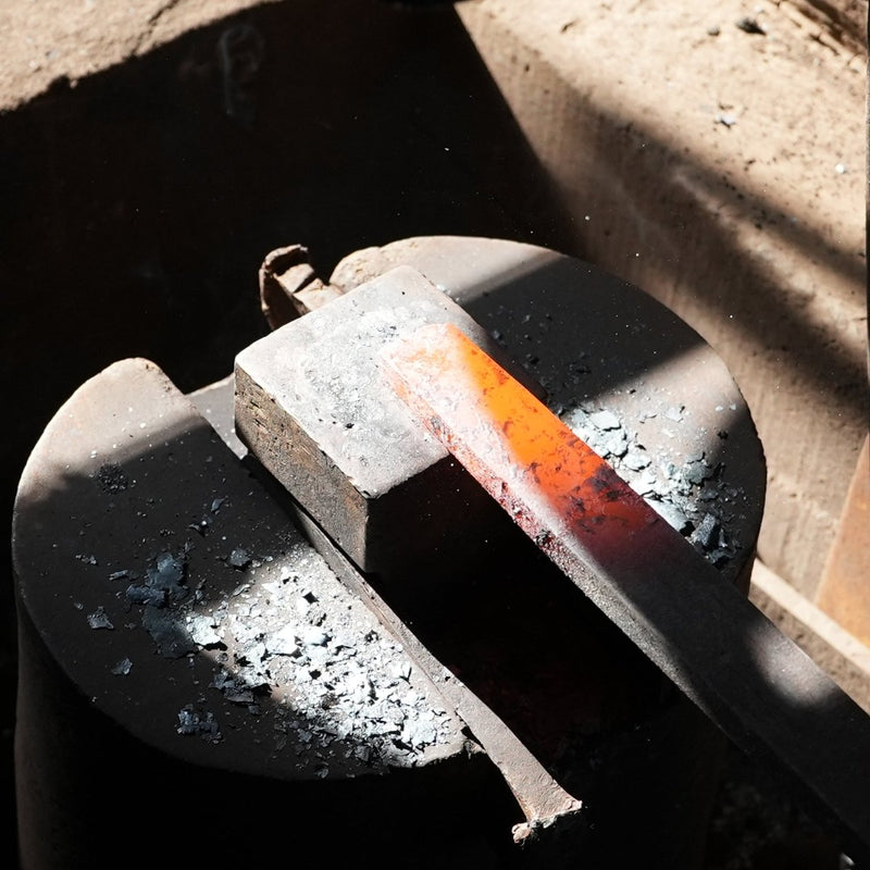 Closeup of a heated metal bar in the hammering station inside Kabayama Blacksmith workshop