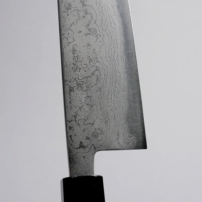 Closeup on engraving on Polished Finish Damascus Blue Steel No. 2 Kiritsuke 210mm on grey background