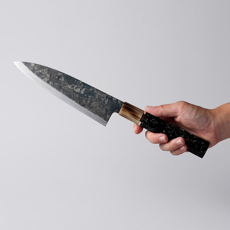 Hand holding a Shirou Kunimitsu Special White Steel Kurouchi Santoku Knife 170mm (Golden Leaf Ebony Handle) 