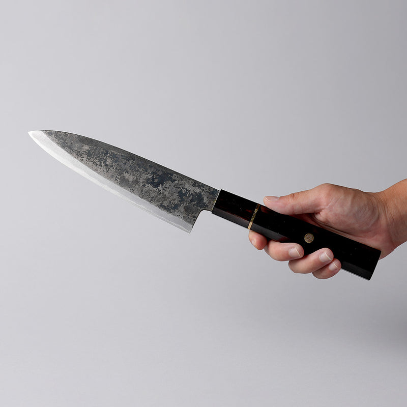 Hand holding a Shirou Kunimitsu Special White Steel Kurouchi Santoku Knife 170mm (Ebony Wood Handle)