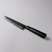 蓑毛鍛冶屋 黒打 牛刀包丁 No.9 230mm グレー背景に斜めに展示