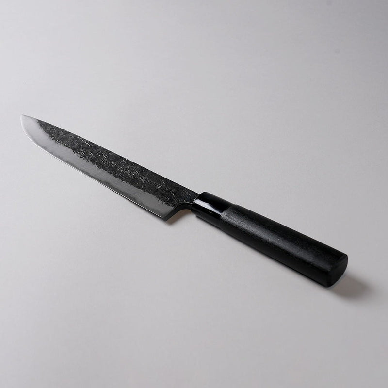 蓑毛鍛冶屋 黒打 牛刀包丁 No.9 230mm グレー背景に斜めに展示