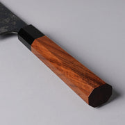 Closeup of the red handle of a Shirou Kunimitsu Special White Steel Kurouchi Santoku Knife 170mm