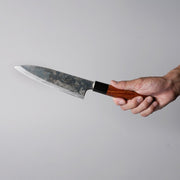 Hand holding a Shirou Kunimitsu Special White Steel Kurouchi Santoku Knife 170mm (Red Handle) 