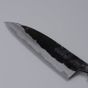 Closeup on blade with engraving of Kurouchi Santoku Knife 150mm crafted by Nakamura Blacksmith displayed diagonally on grey background