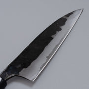 Closeup on blade of Kurouchi Santoku Knife 150mm crafted by Nakamura Blacksmith displayed diagonally on grey background