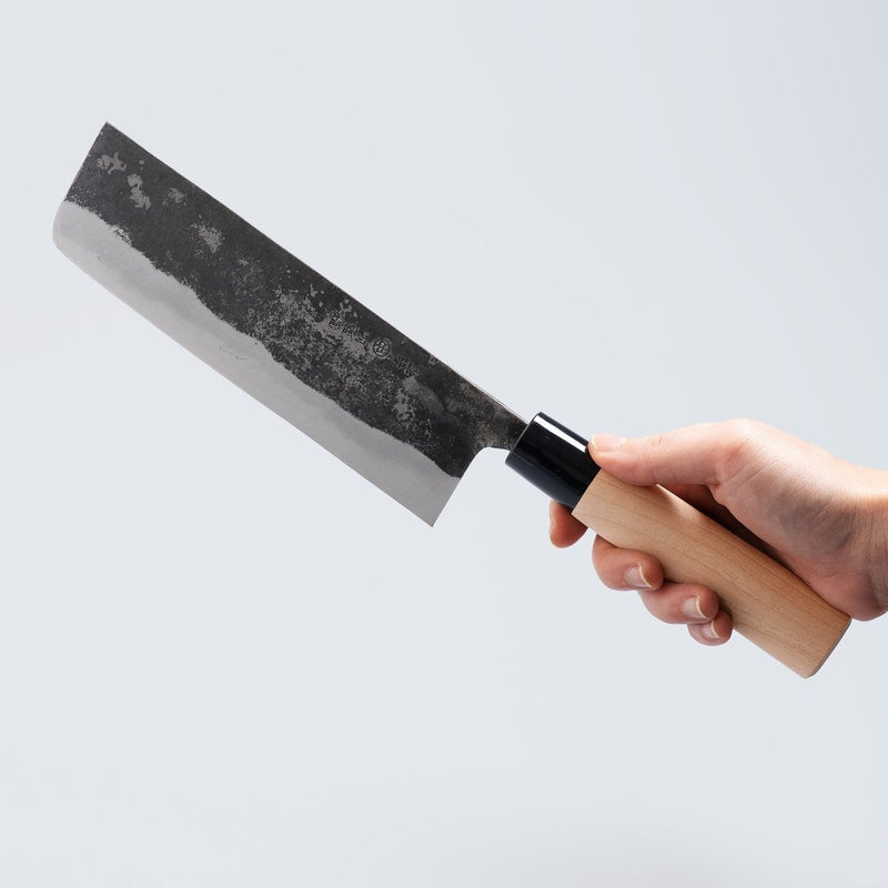 Hand holding a Nakamura Hamono Kurouchi Nakiri Knife 170mm