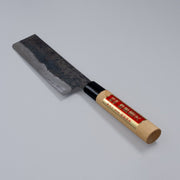 Single-Bevel Kurouchi Nakiri Knife 160mm crafted by Shirou Kunimitsu displayed diagonally on grey background