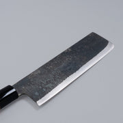 Closeup on sharpened edge of Single-Bevel Kurouchi Nakiri Knife 160mm crafted by Shirou Kunimitsu on grey background