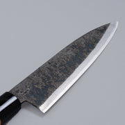 Closeup on sharpened edge of single-Bevel Kurouchi Santoku Knife 170mm crafted by Shirou Kunimitsu on grey background