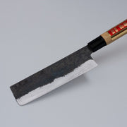 Closeup on tip of Single-Bevel Kurouchi Nakiri Knife 160mm crafted by Shirou Kunimitsu displayed diagonally on grey background