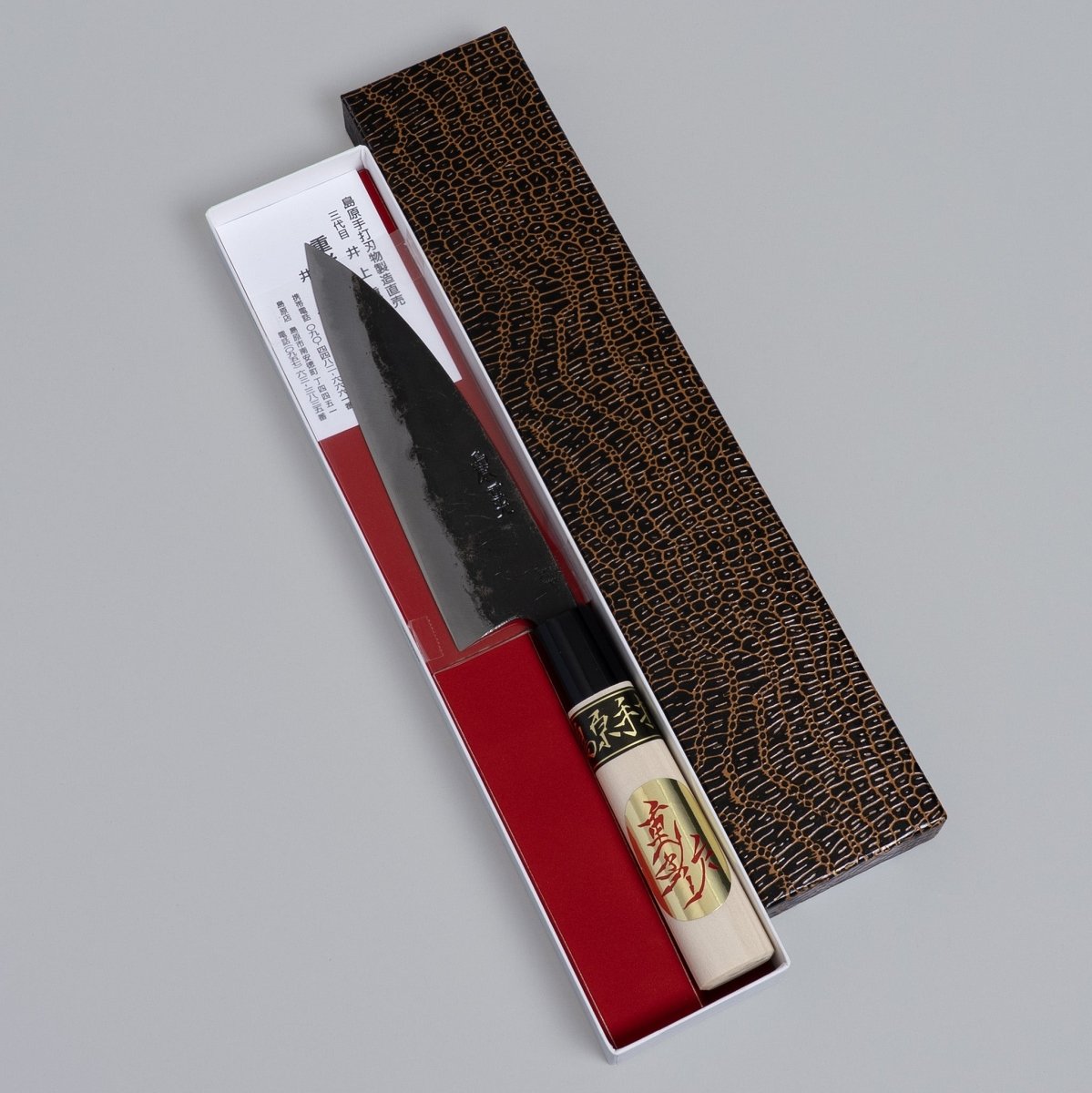 Kurouchi Deba knife 155mm crafted by Shigemitsu Hamono in decorative box on grey background 