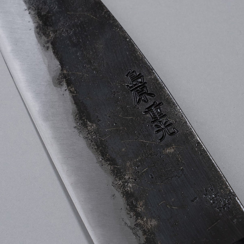 Closeup on engraving on blade of Kurouchi Santoku knife 160mm crafted by Shigemitsu Hamono on grey background 