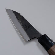 Closeup of the blade of a Nishida Hamono Kurouchi Petty Knife 100mm with maker's engraving