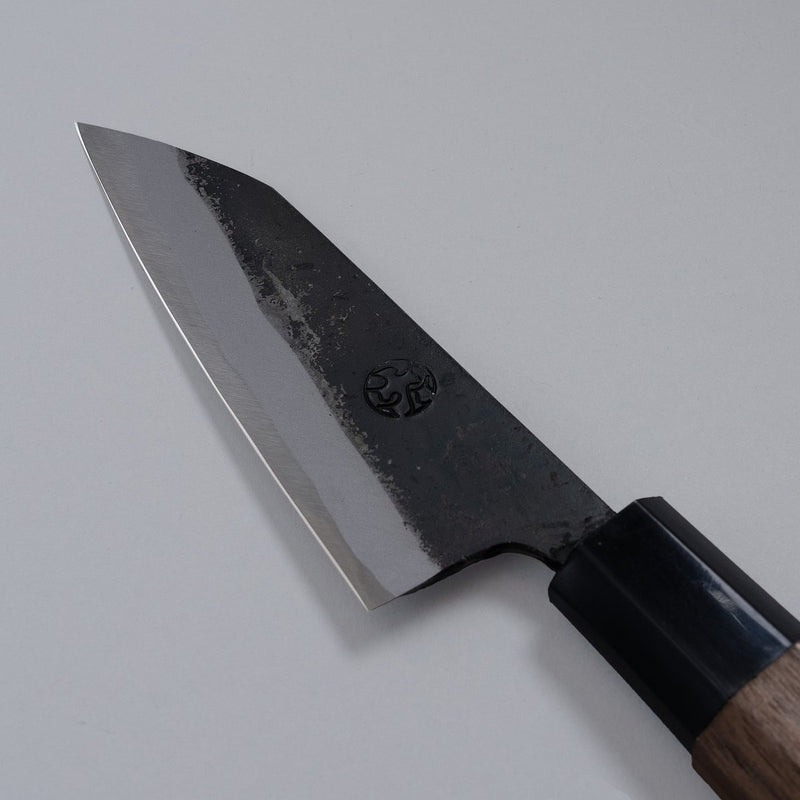 Closeup of the blade of a Nishida Hamono Kurouchi Petty Knife 100mm with maker's engraving