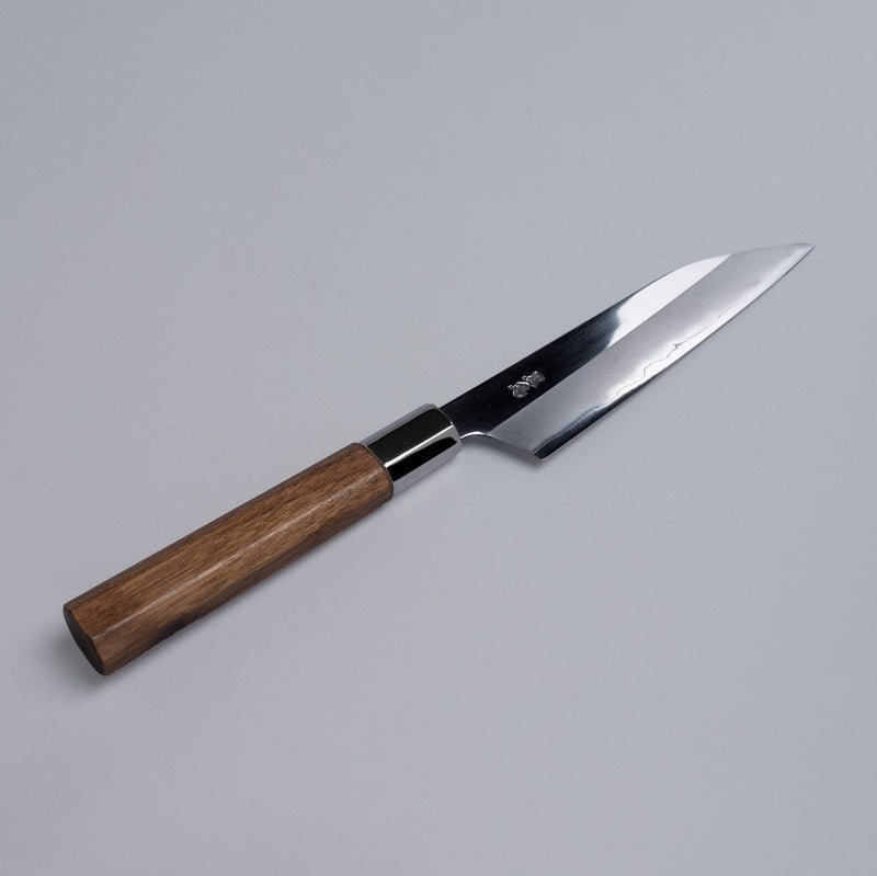 Ginsan stainless Petty knife 135mm crafted by Kurotori Blacksmith displayed diagonally on grey background