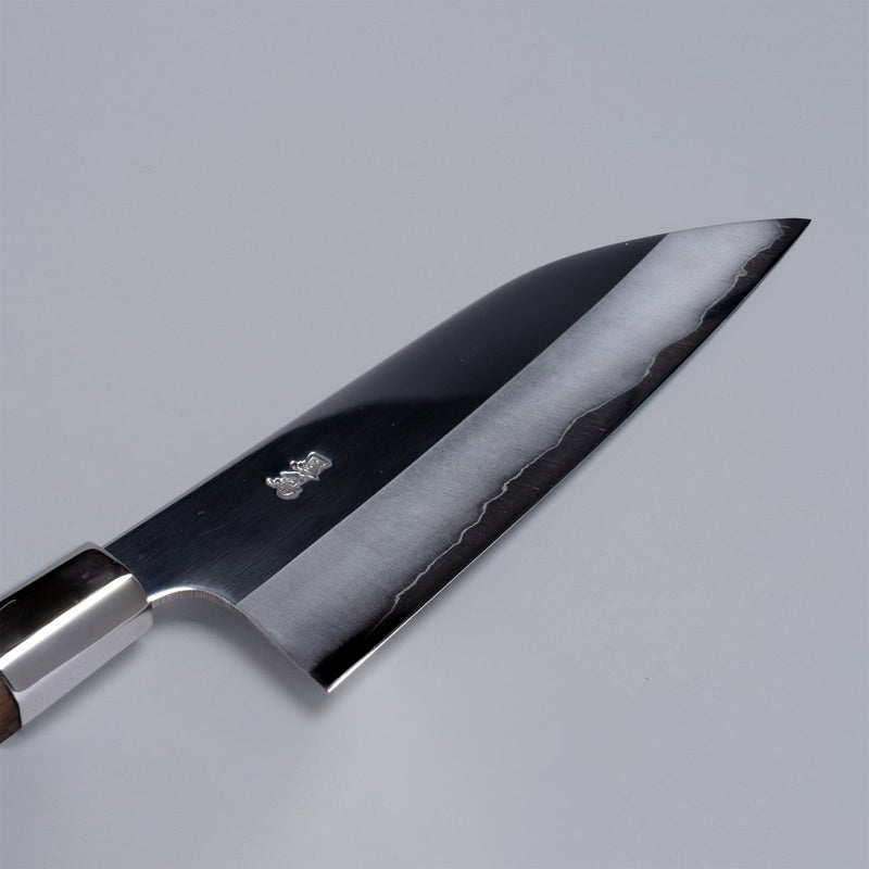 Closeup on engraving on ginsan stainless Funayuki knife 165mm crafted by Kurotori Blacksmith on grey background