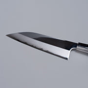 Closeup on reverse edge of ginsan stainless Funayuki knife 165mm crafted by Kurotori Blacksmith on grey background