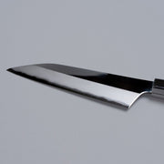 Closeup on reverse side of blade of ginsan stainless Petty knife 135mm crafted by Kurotori Blacksmith on grey background