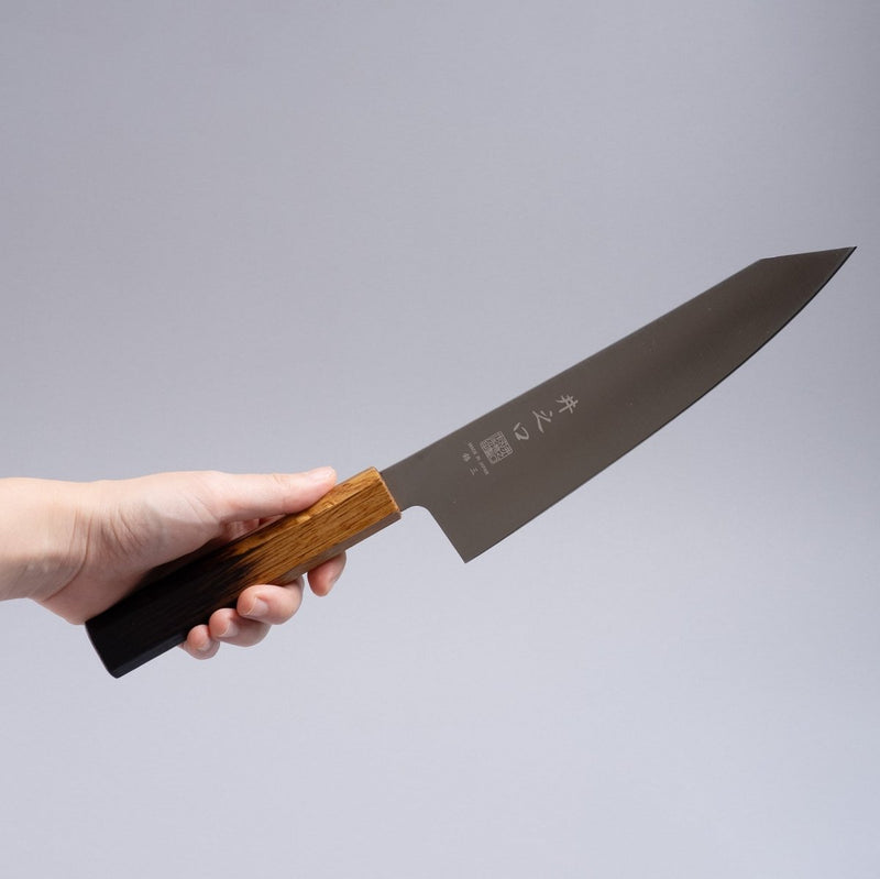 Hand holding a Inoguchi Hamono Japanese Kiritsuke Santoku Knife 210mm (Japanese Oak Urushi Lacquer Brown)