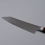 Closeup on reverse side of blade of VG-10 stainless steel KIRINAMI Kiritsuke Bunka 180mm by Seki Kikusui Cutlery on grey background