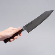 VG-10 stainless steel KIRINAMI Kiritsuke Bunka 180mm crafted by Seki Kikusui Cutlery displayed diagonally in hand on grey background