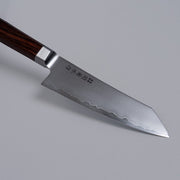 Closeup on tip of VG-10 stainless steel KIRINAMI Kiritsuke Bunka 150mm crafted by Seki Kikusui Cutlery on grey background