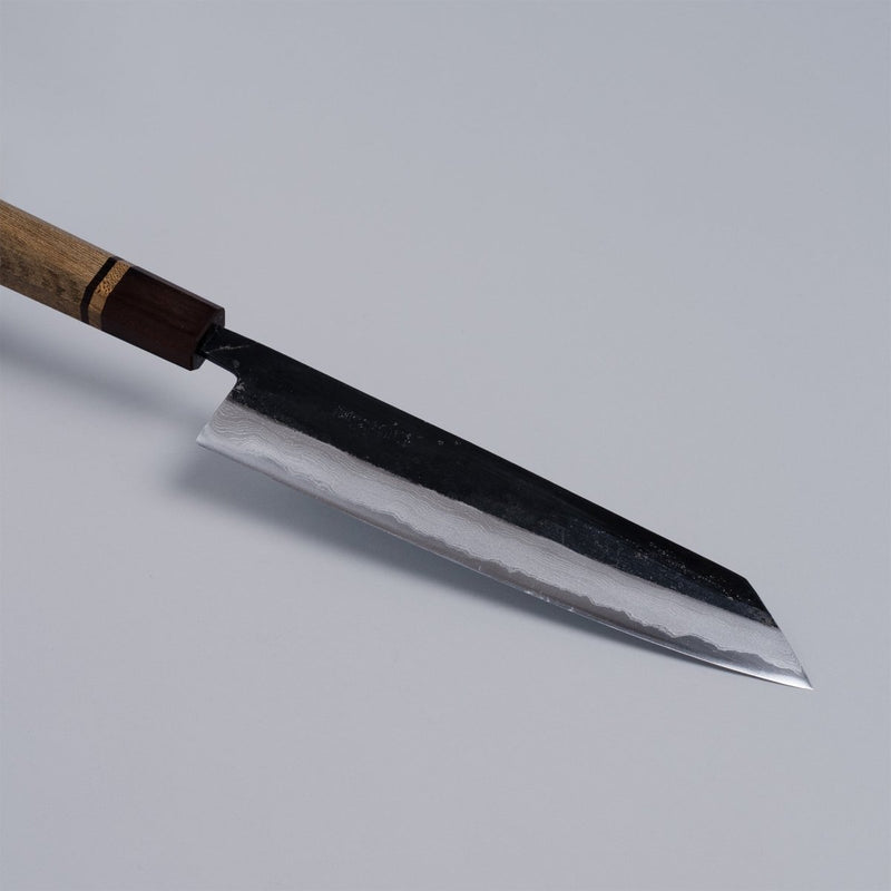 Closeup on tip of Kurouchi Damascus Blue Steel No. 2 Kiritsuke 210mm by Kajihara Hamono on grey background