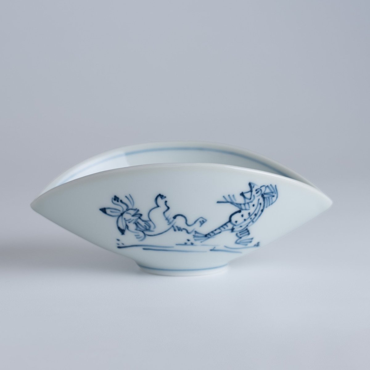 Closeup of the side of Koenji Sugagasa Porcelain Appetizer Plate with frolicking animals print